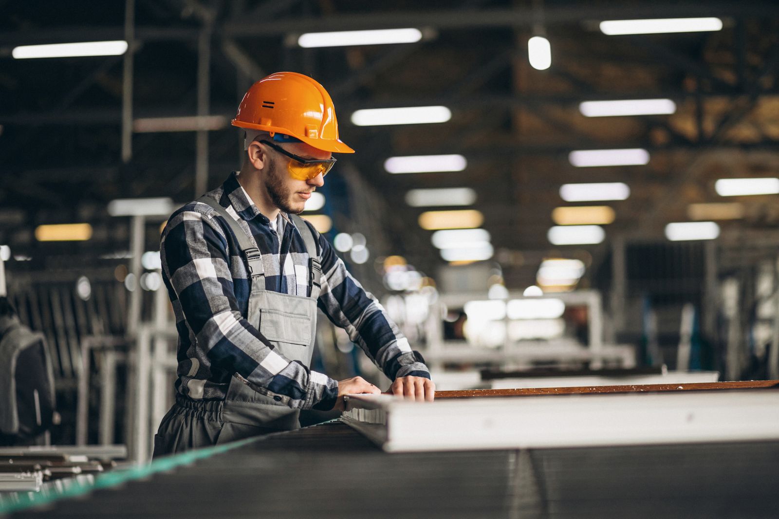 Trabajador con casco y lentes de seguridad en una planta industrial